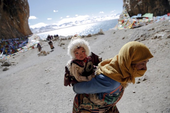 a-mother-and-child-visit-namtso-lake-at-more-than-15000-feet-above-sea-level-its-the-highest-saltwater-lake-in-the-world