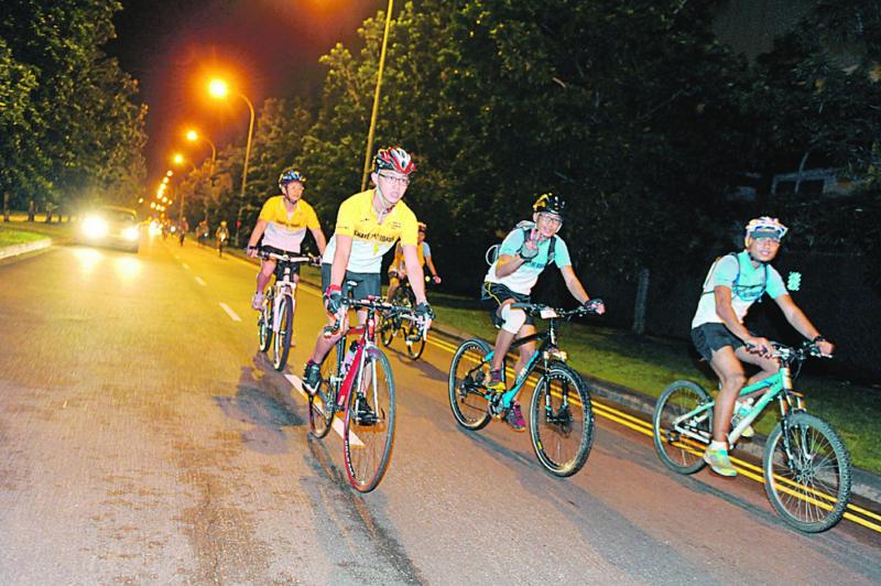 A few cyclists on their bicycles cycling at night. See a side of Singapore you rarely glimpse on night time cycle. Photo credit: Money Sense
