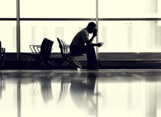 man-sitting-at-airport-hero-airport airline travel tips
