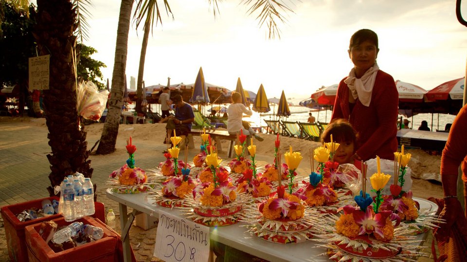 Pattaya Beach featuring shopping and a sunset as well as a small group of people