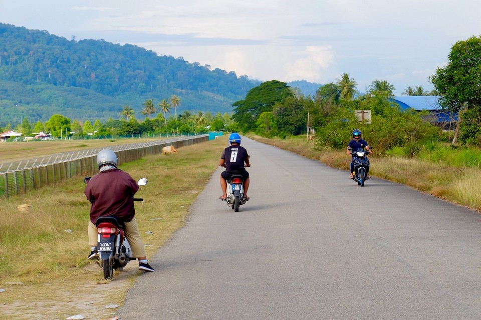 Men on scooters in Langkawi, Malaysia