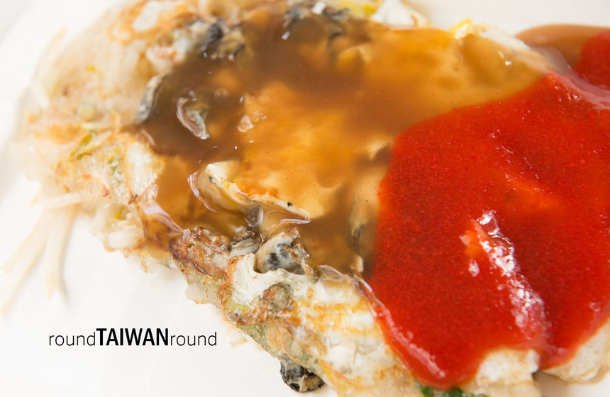 Enjoying oyster omelet with chili sauce