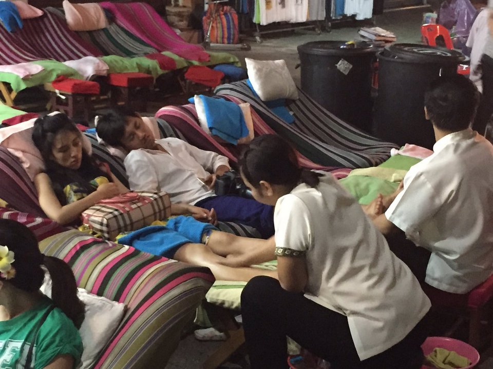 The girls joining the locals for a massage in the street market